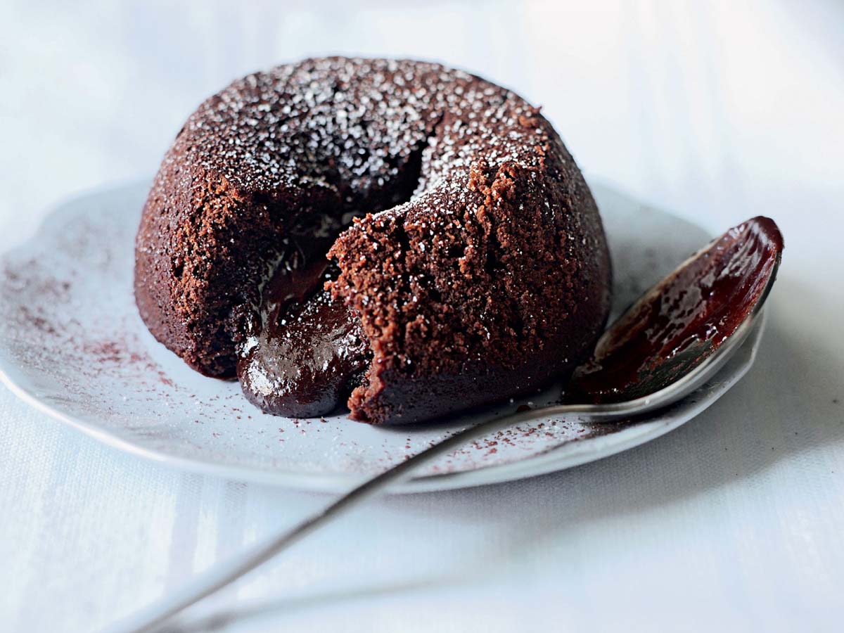 A rich chocolate fondant cake with a gooey, molten chocolate center flowing out.