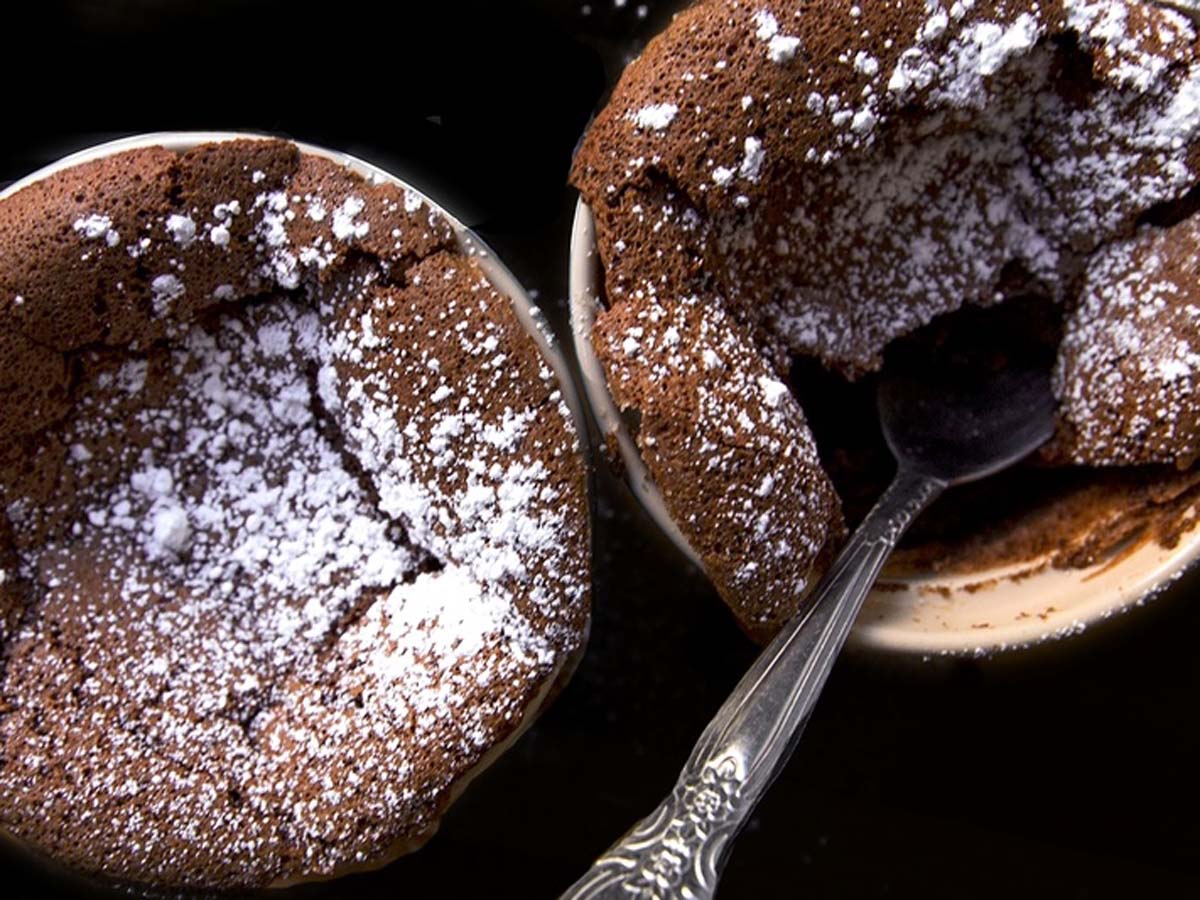 A perfectly risen, light and airy hot chocolate souffle dusted with powdered sugar.
