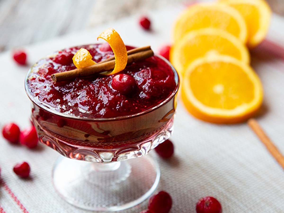 A dish of bright red, sweet and tart homemade cranberry sauce condiment mix.