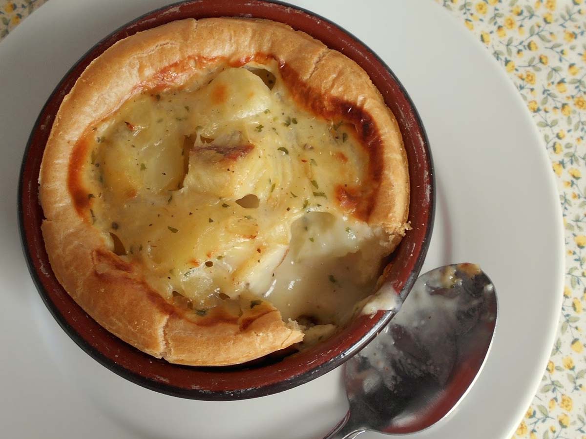 A rich creamy fish pie topped with a unique, airy choux pastry baked crust.