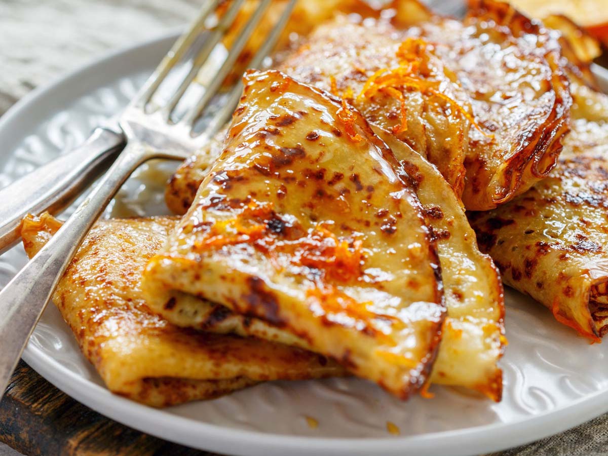 Thin French crepes suzette dessert swimming in a flaming orange butter and Grand Marnier sauce.