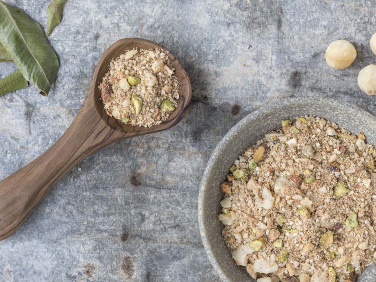 A bowl of crunchy Egyptian Dukkah spice mix containing crushed nuts, seeds, and spices.