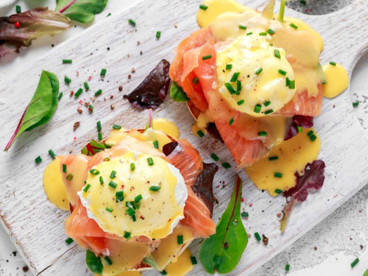 A premium eggs benedict version topped with poached eggs and luxury ribbons of smoked salmon.