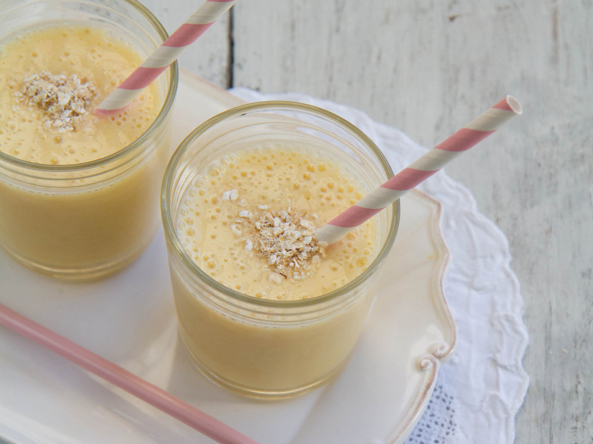 A colorful mixed fruit smoothie drink showing layers of blended tropical fruits.