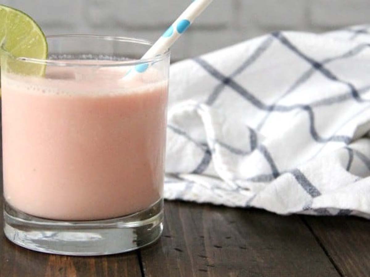 A refreshing pink blended tropical guava smoothie inside a clean glass jar.