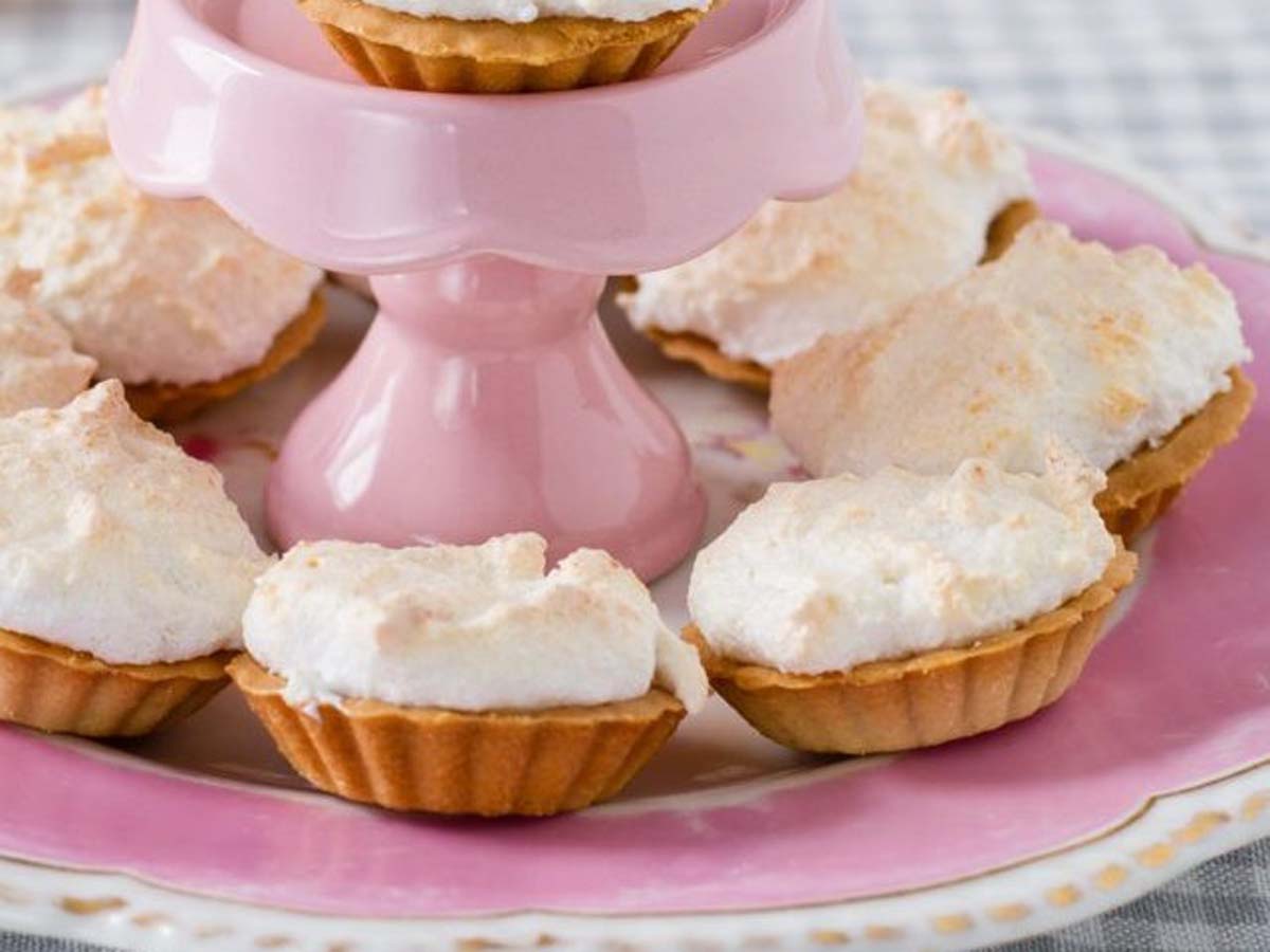 Traditional South African Hertzoggies with a sweet pastry crust, jam filling, and coconut meringue topping.