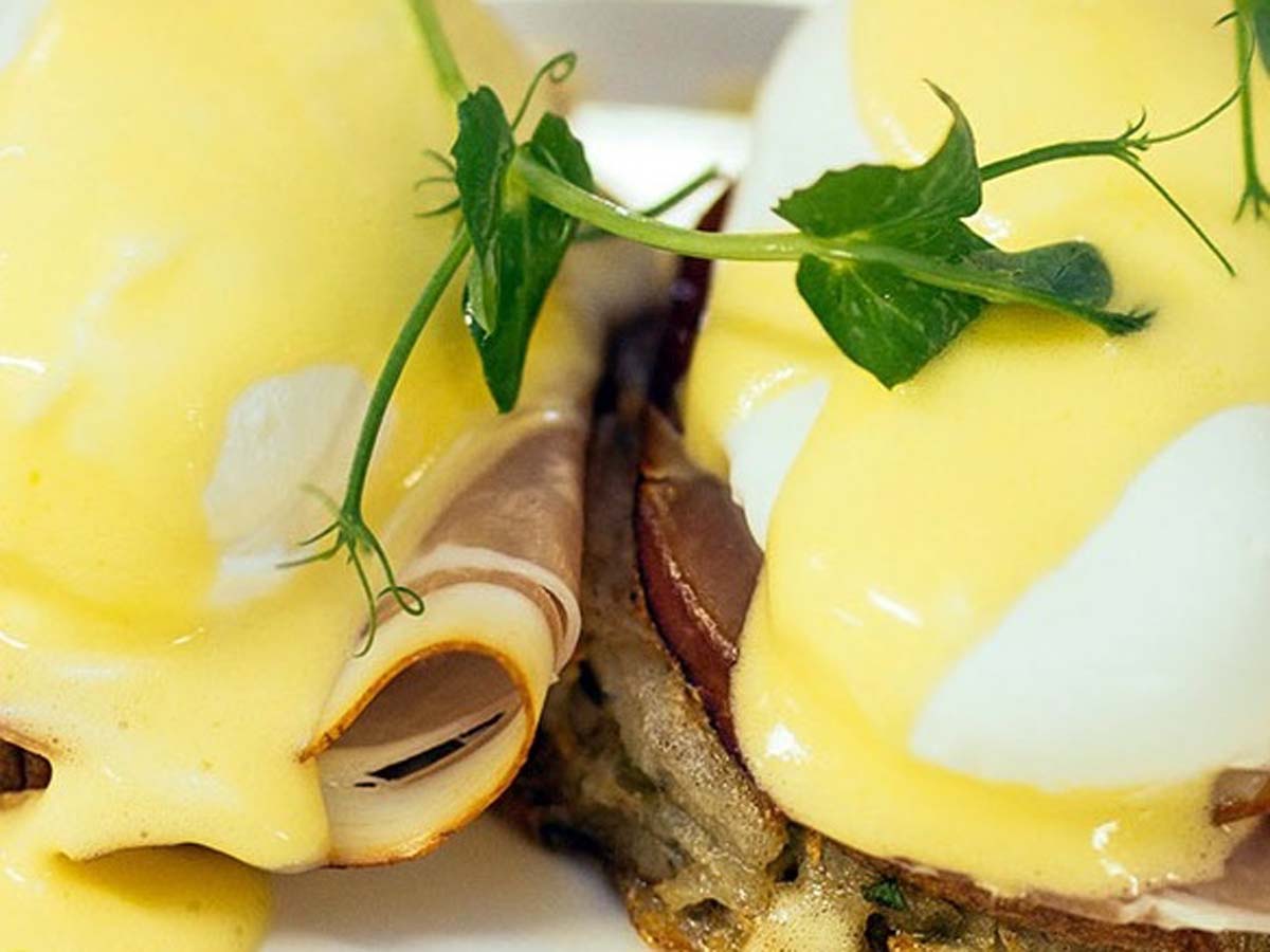 Smooth and velvety yellow homemade Hollandaise sauce served in a small bowl.