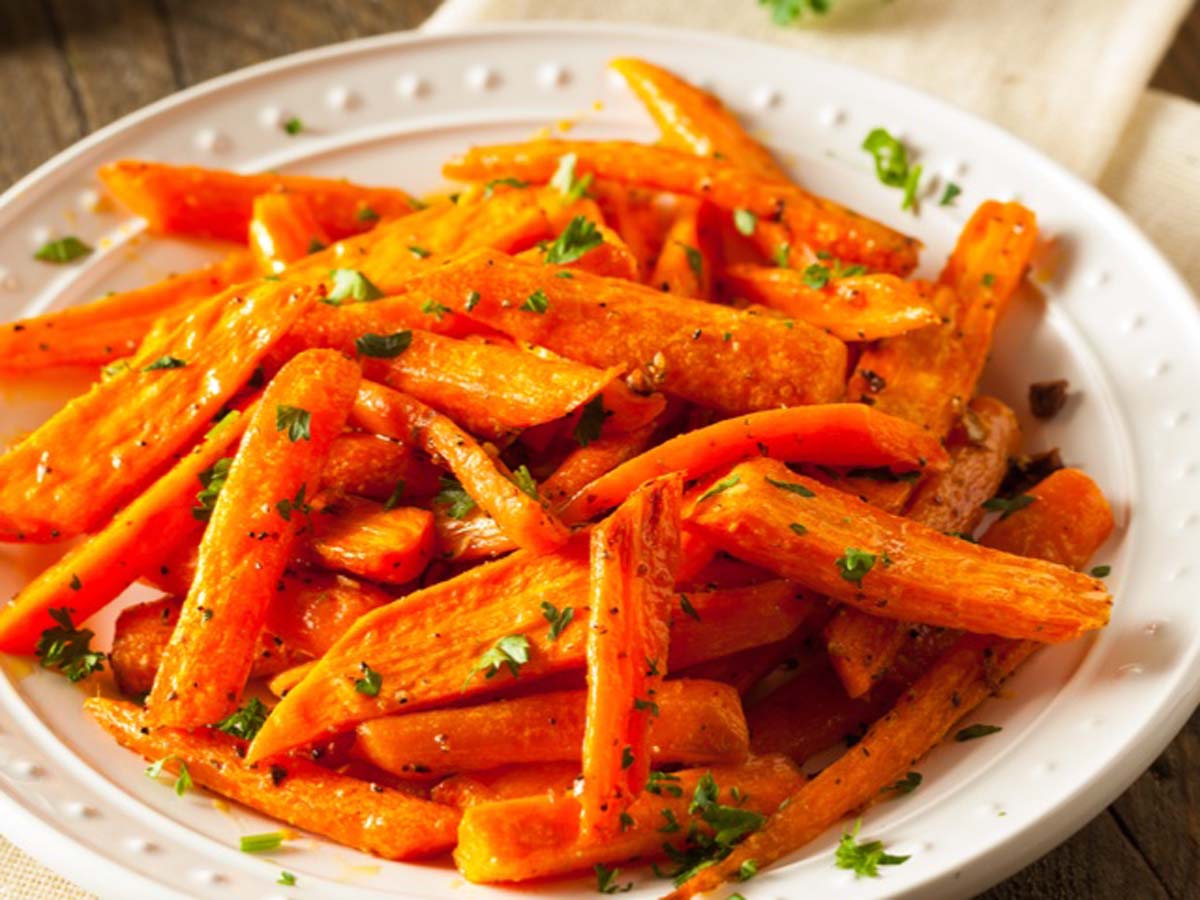 A side dish of sweet, glossy honey glazed carrots cut into coins.