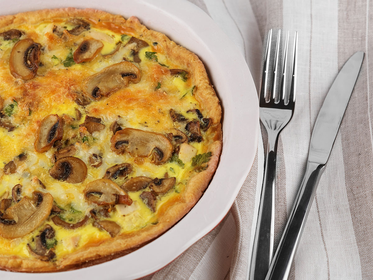 A gourmet omelet combining sautéed mushrooms, wilted spinach leaves, and crumbled feta cheese.