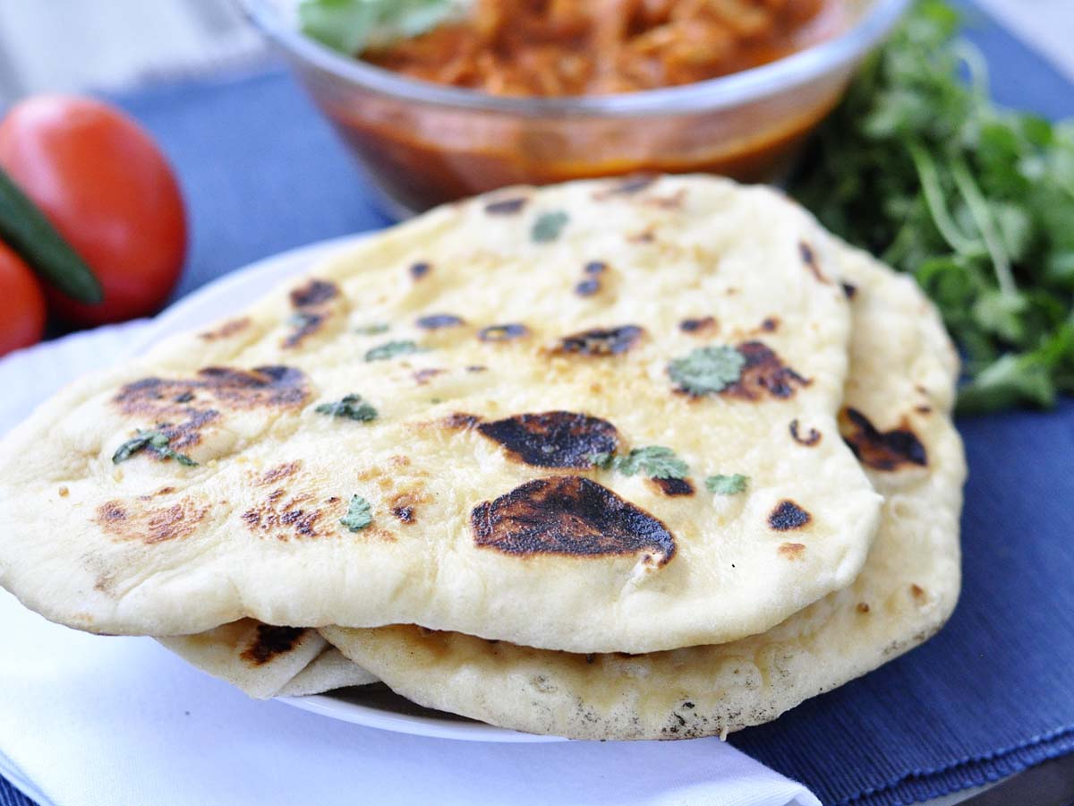 Soft, charred and puffy Indian naan bread fresh from the hot tandoor oven.