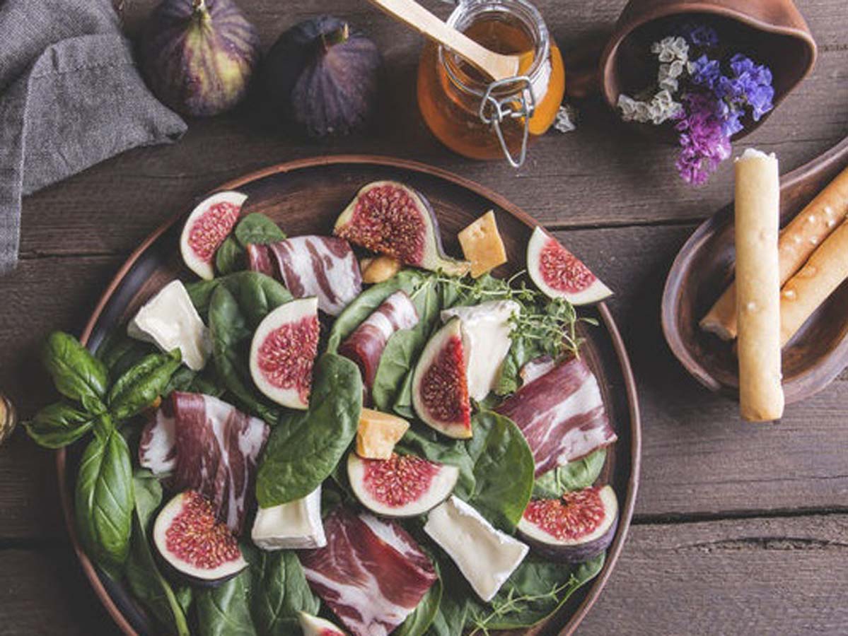 An elegant salad of cured Parma ham, sweet figs, and soft bocconcini mozzarella balls.