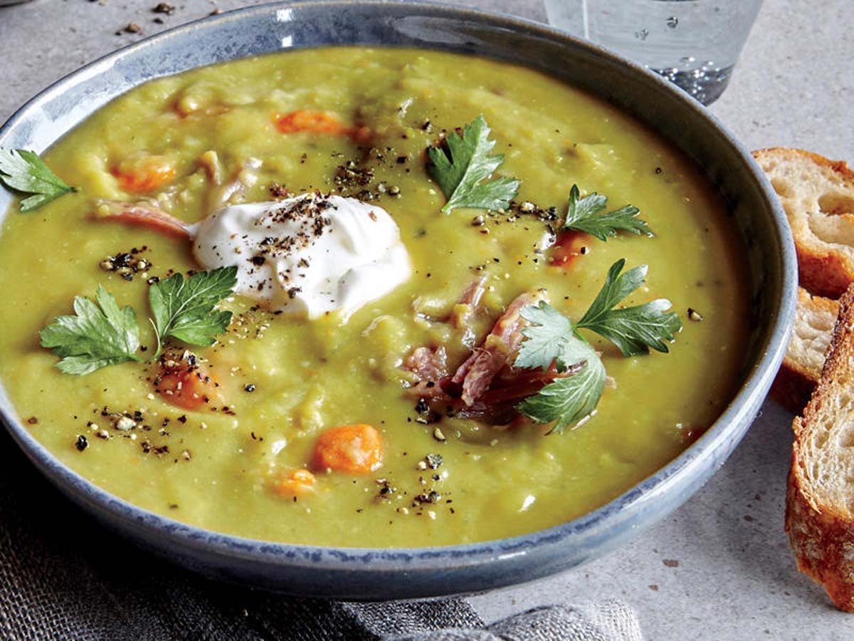 A thick, hearty green pea and ham soup cooked with tender smoked ham hock pieces.