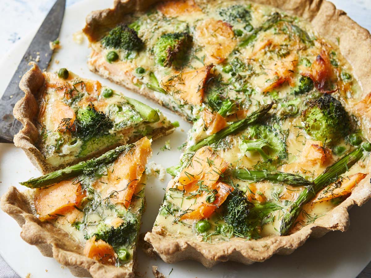 Raw, flaky quiche pastry dough pressed perfectly into a ceramic tart dish.