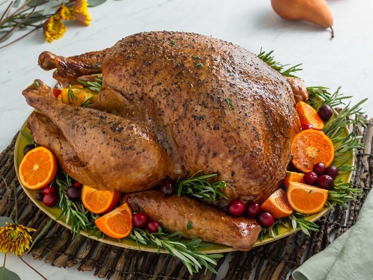 A magnificent whole golden brown roast turkey served on a festive holiday dinner table.