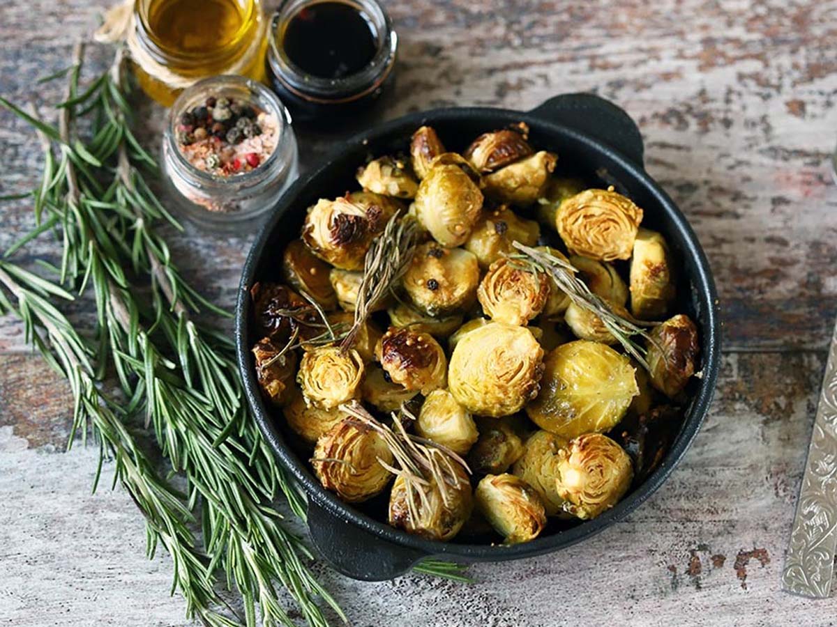 A sheet pan of crispy roasted oven-baked whole Brussels sprouts seasoned with garlic.