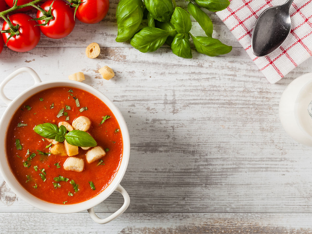 A vibrant orange roasted red pepper soup crumbled with salty white feta cheese.