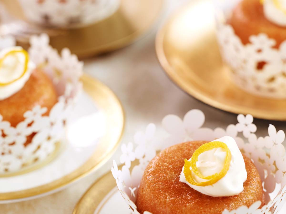 Spongy rum baba yeast cakes soaked in sweet rum syrup and topped with cream.