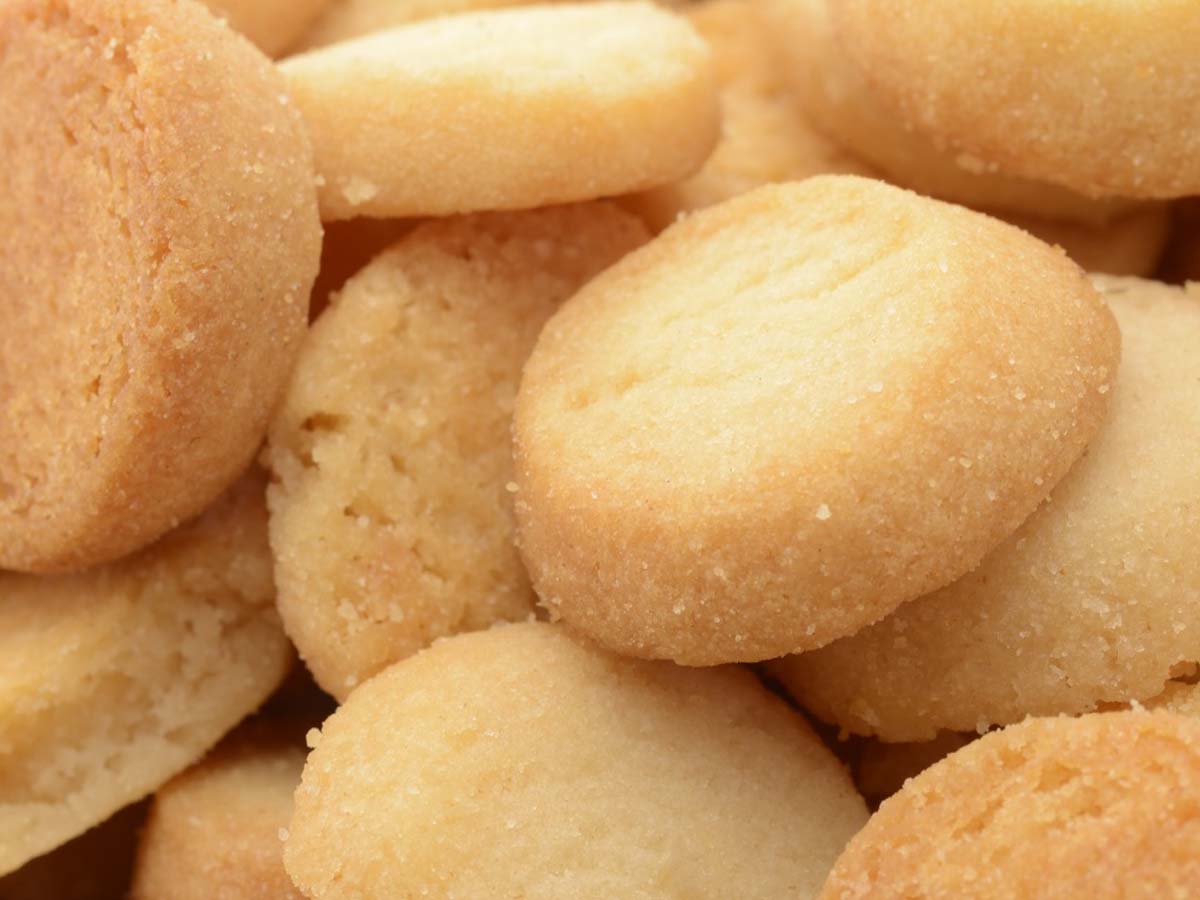 Delicate small shortbread biscuits arranged neatly, showing a light and crumbly texture.