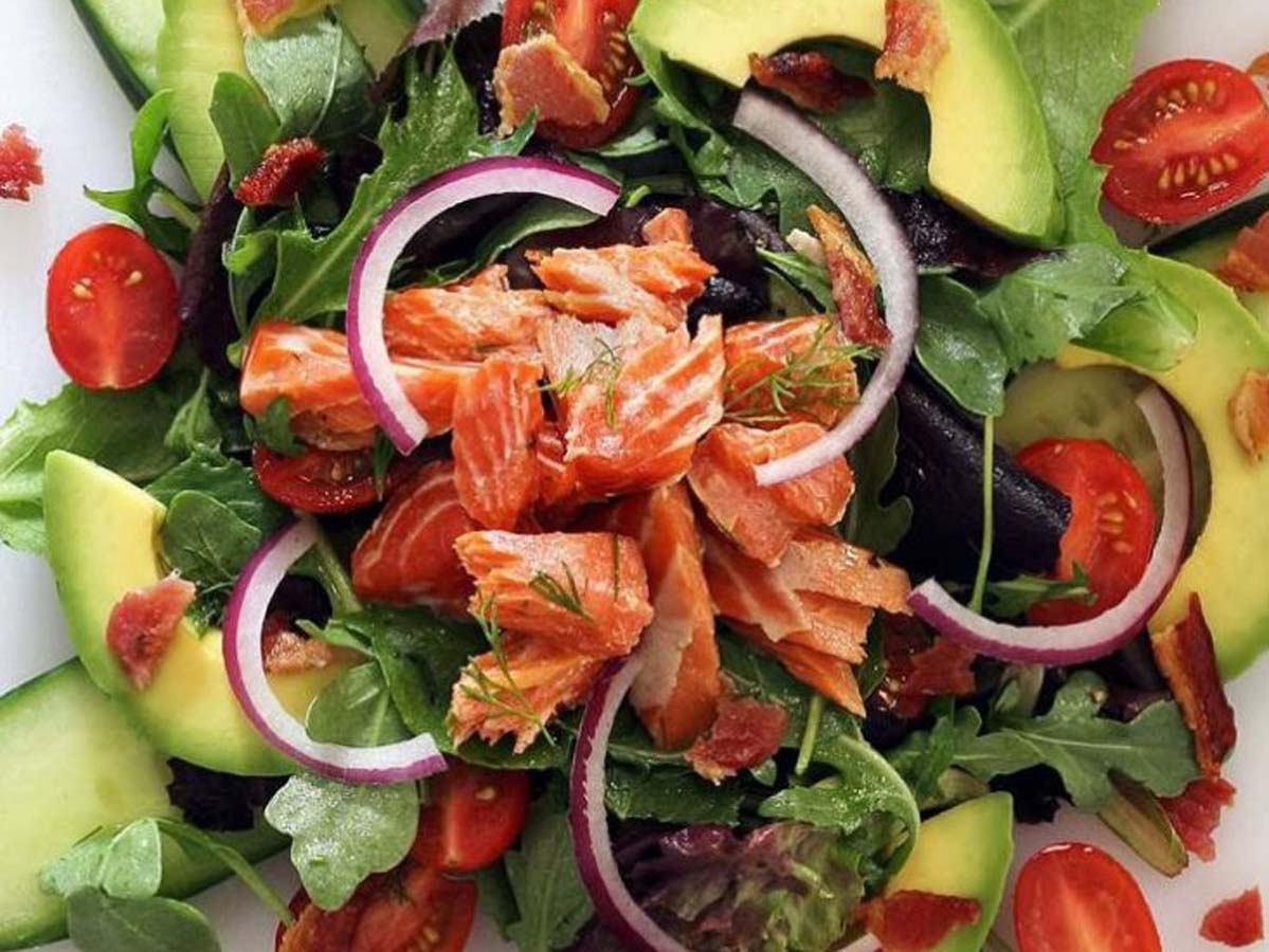 A premium smoked salmon salad with delicate pink salmon ribbons and fresh cucumber.