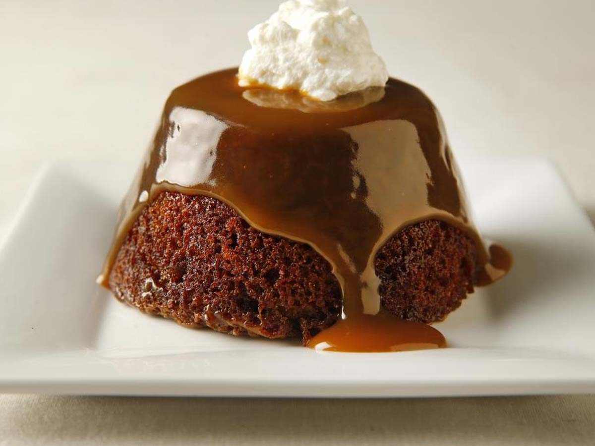 A rich, dark sticky toffee pudding square drenched in warm butterscotch sauce.