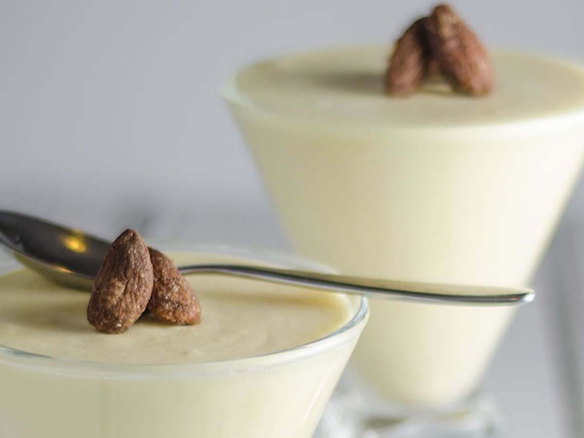 A delicate, airy glass cup filled with sweet white chocolate mousse dessert cream.